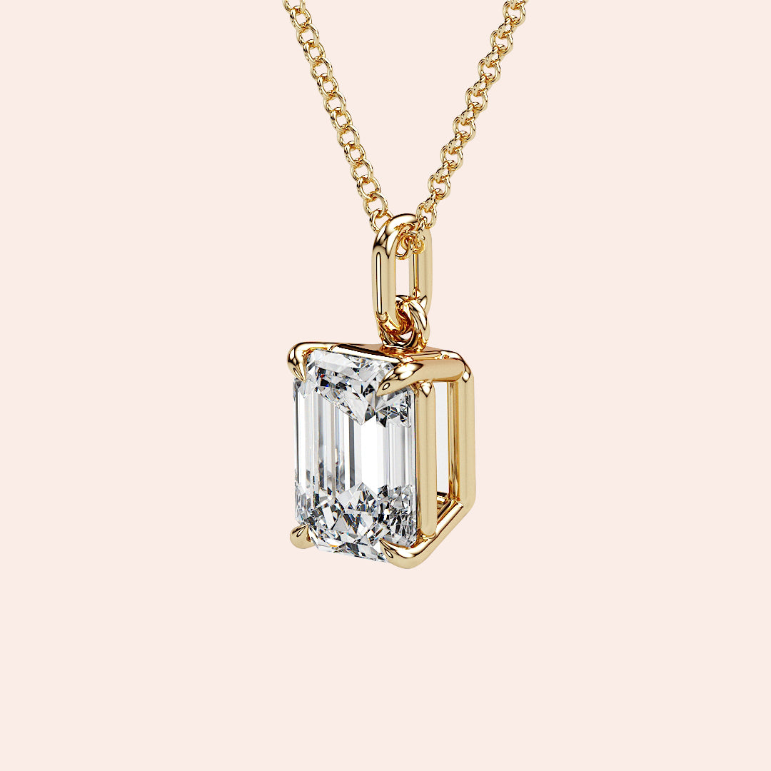 A detailed side view of an emerald-cut diamond solitaire pendant in a four-prong yellow gold basket setting. The intricate craftsmanship and secure setting highlight the beauty and precision of this classic piece.
| #14KRecycledYellowGold #18KRecycledYellowGold
