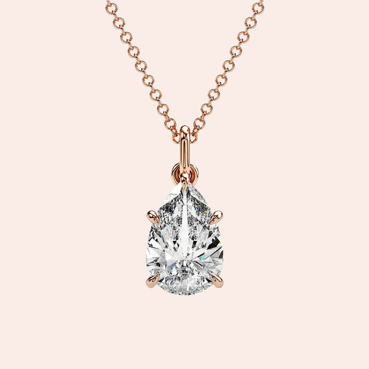 A close-up of a pear-shaped diamond solitaire pendant, securely set in a four-prong rose gold setting. The diamond’s unique shape exudes grace and brilliance. 