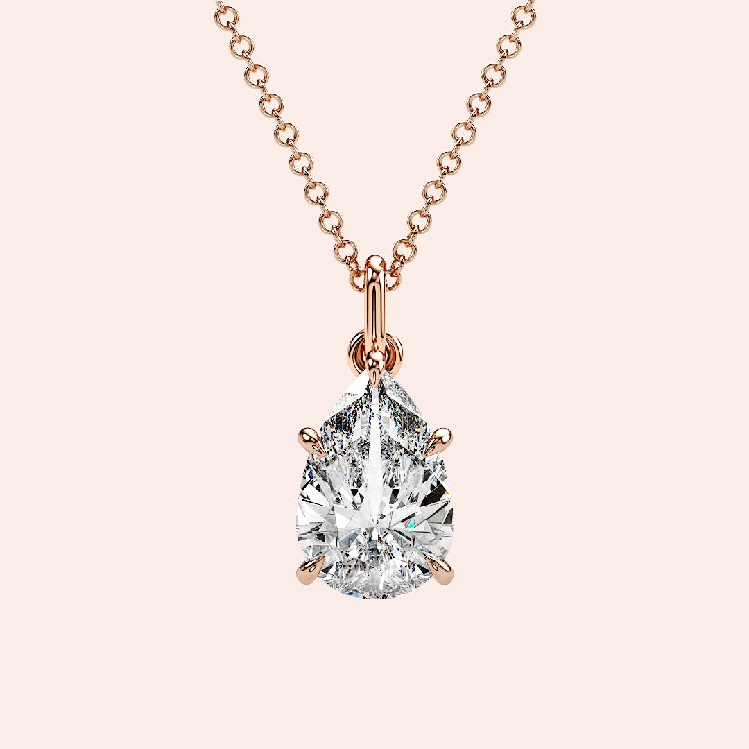 A close-up of a pear-shaped diamond solitaire pendant, securely set in a four-prong rose gold setting. The diamond’s unique shape exudes grace and brilliance. 