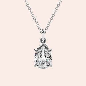 A radiant woman showcasing a pear-shaped diamond solitaire pendant in white gold. This delicate yet striking design enhances her look with understated elegance.
