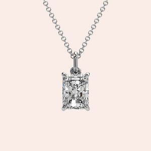 A close-up of a solitaire radiant-cut diamond pendant in a classic four-prong white gold setting. The clean lines and exquisite craftsmanship highlight the stone’s unique facets.
