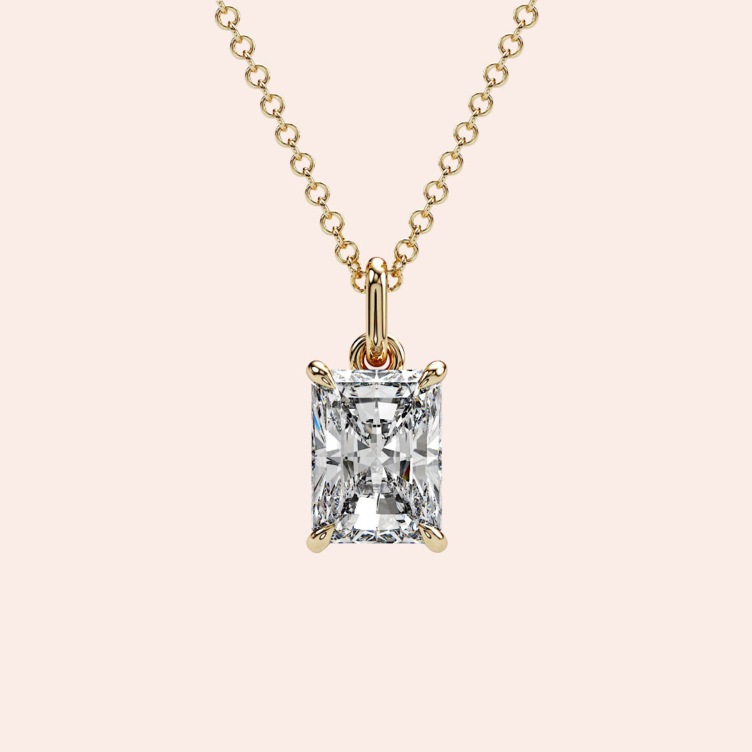 A close-up of a radiant-cut solitaire diamond pendant in a four-prong yellow gold setting. The structured shape of the radiant cut enhances the diamond's brilliance and fire.
| #14KRecycledYellowGold #18KRecycledYellowGold