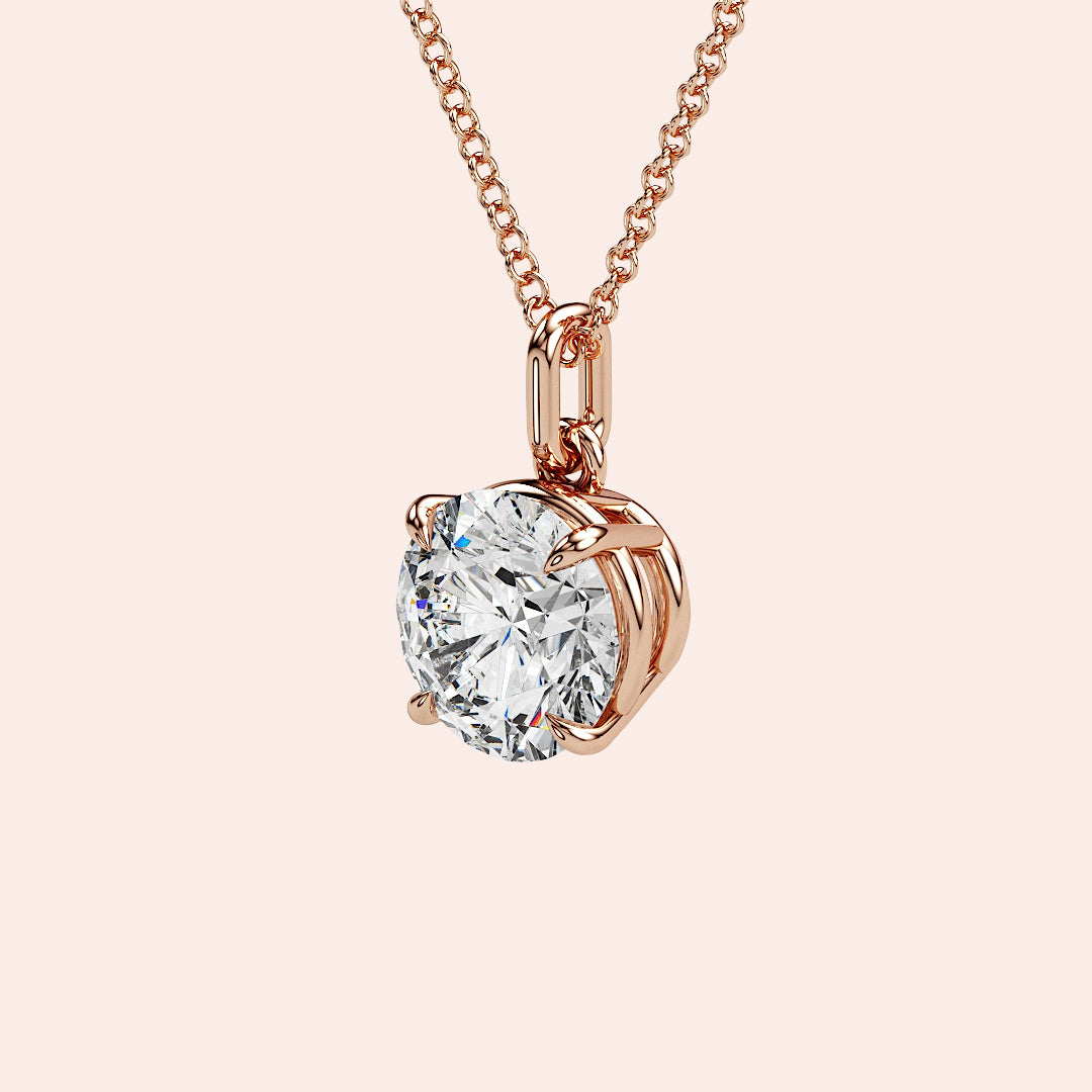 A detailed side view of a round-cut diamond solitaire pendant in a four-prong rose gold basket setting. The intricate craftsmanship and refined design highlight the pendant’s timeless charm.
