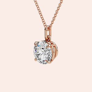 A detailed side view of a round-cut diamond solitaire pendant in a four-prong rose gold basket setting. The intricate craftsmanship and refined design highlight the pendant’s timeless charm.
