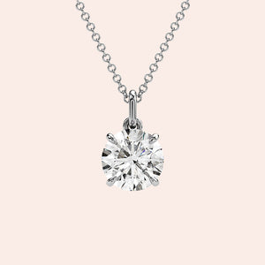 A close-up of a solitaire round-cut diamond pendant in a classic four-prong white gold setting. The pendant’s design ensures maximum brilliance and elegance.
