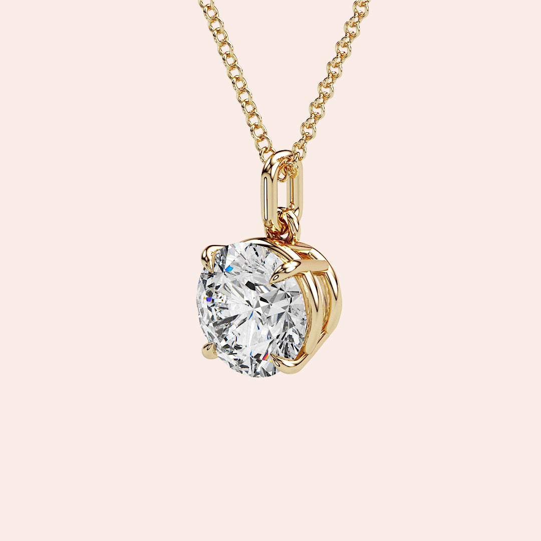 A detailed side view of a round-cut diamond solitaire pendant in a four-prong yellow gold basket setting. The intricate craftsmanship and refined design highlight the pendant’s timeless appeal.
