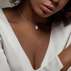 Pear diamond solitaire necklace in white gold, fine jewelry pendant styled on model, timeless and feminine everyday piece 