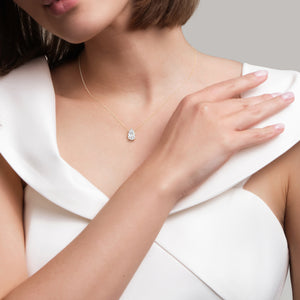Pear diamond solitaire necklace in yellow gold, fine jewelry pendant styled on model, timeless and feminine everyday piece 