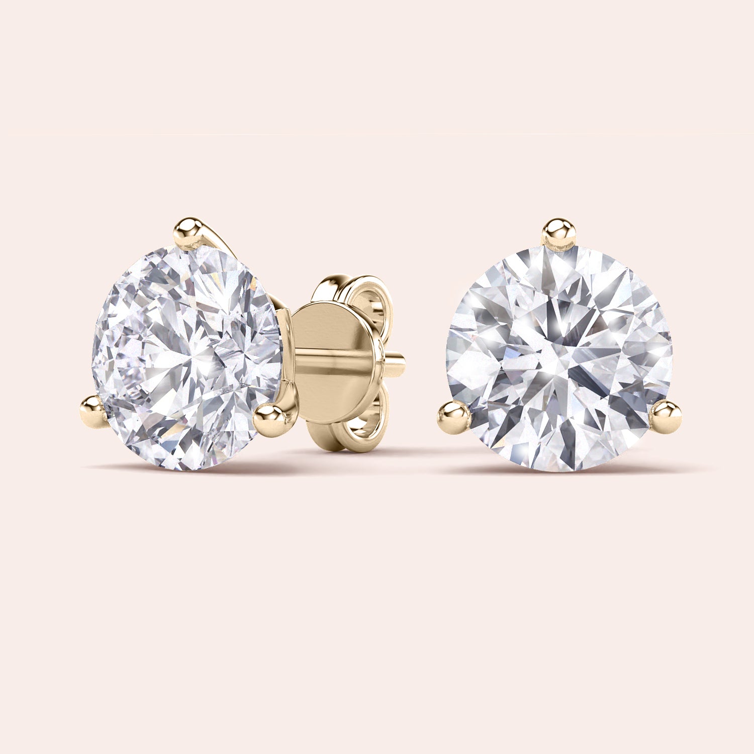 Luxurious 3-Prong Martini Diamond Earrings in yellow gold, isolated on beige background 