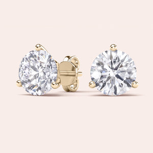Luxurious 3-Prong Martini Diamond Earrings in yellow gold, isolated on beige background 