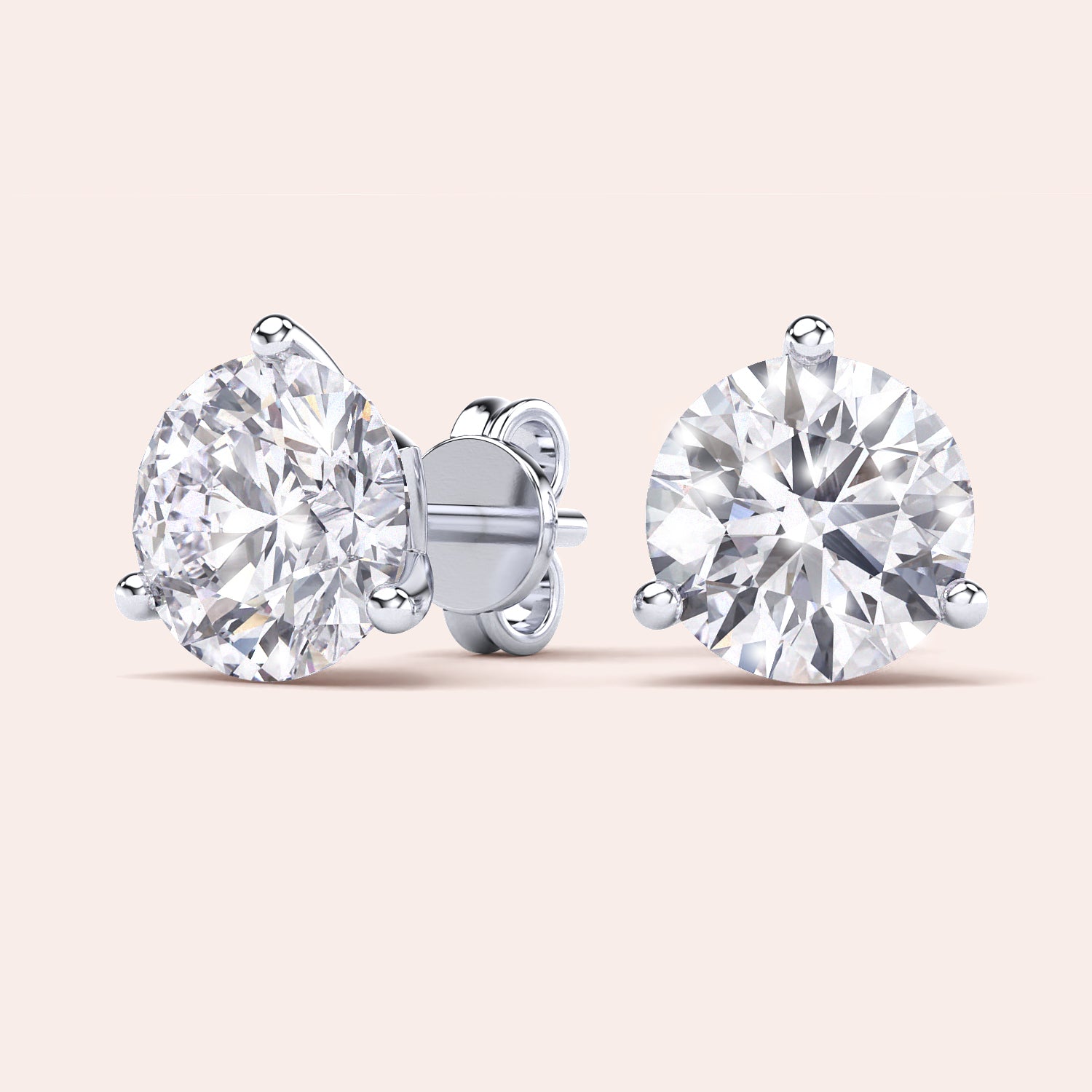 Timeless 3-Prong Martini Diamond Stud Earrings in white gold on a soft pink background |

#14KRecycledWhiteGold
#18KRecycledWhiteGold
#Platinum

