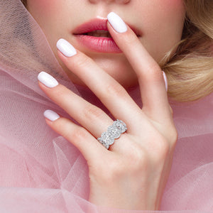 Elegant 14K white gold eternity ring with round brilliant diamonds, worn on model's hand, perfect for weddings and special occasions. 