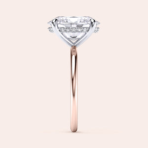 Two-tone 14K/18K white and rose gold engagement ring featuring an oval-cut diamond in a heart-shaped secret halo design. 
