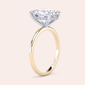 Two-tone 14K white and yellow gold oval-cut diamond solitaire ring, perfect for engagement or wedding, shown on a model's hand. 