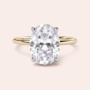 Two-tone 14K yellow and white gold oval diamond ring with secret halo, perfect for elegant engagements. 
