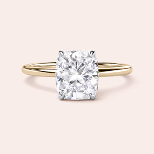 Two-tone 14K/18K gold engagement ring featuring a cushion-cut diamond in white and yellow gold. 