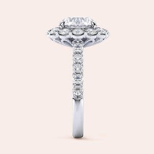 Elegant engagement ring with a radiant-cut diamond in a 14K or 18K gold or platinum band, showcasing a dazzling halo and pavé design.