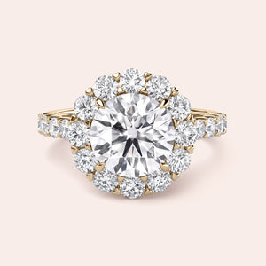 Elegant ring with a round diamond surrounded by a halo of smaller diamonds, available in 14K or 18K gold or platinum.