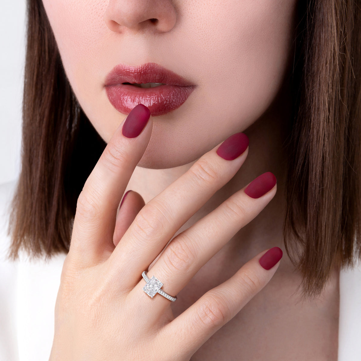 A radiant-cut diamond engagement ring in 14K gold, elegantly worn on a model's finger, showcasing luxury and style.