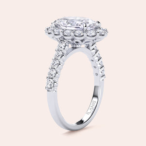 Stunning oval diamond engagement ring in 14K or 18K gold or platinum, featuring a halo design and additional diamonds on the band.
