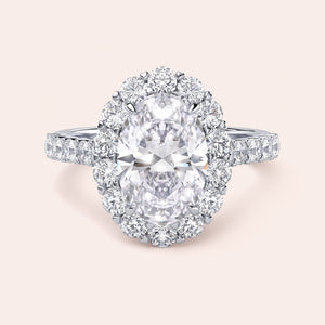 Elegant oval-shaped diamond halo ring in 14K or 18K gold or platinum, featuring sparkling accent stones around the central diamond.
