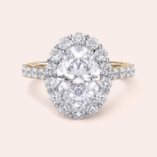 Two-tone 14K white and yellow gold engagement ring featuring an oval diamond, halo, and pave diamond band, unworn. 