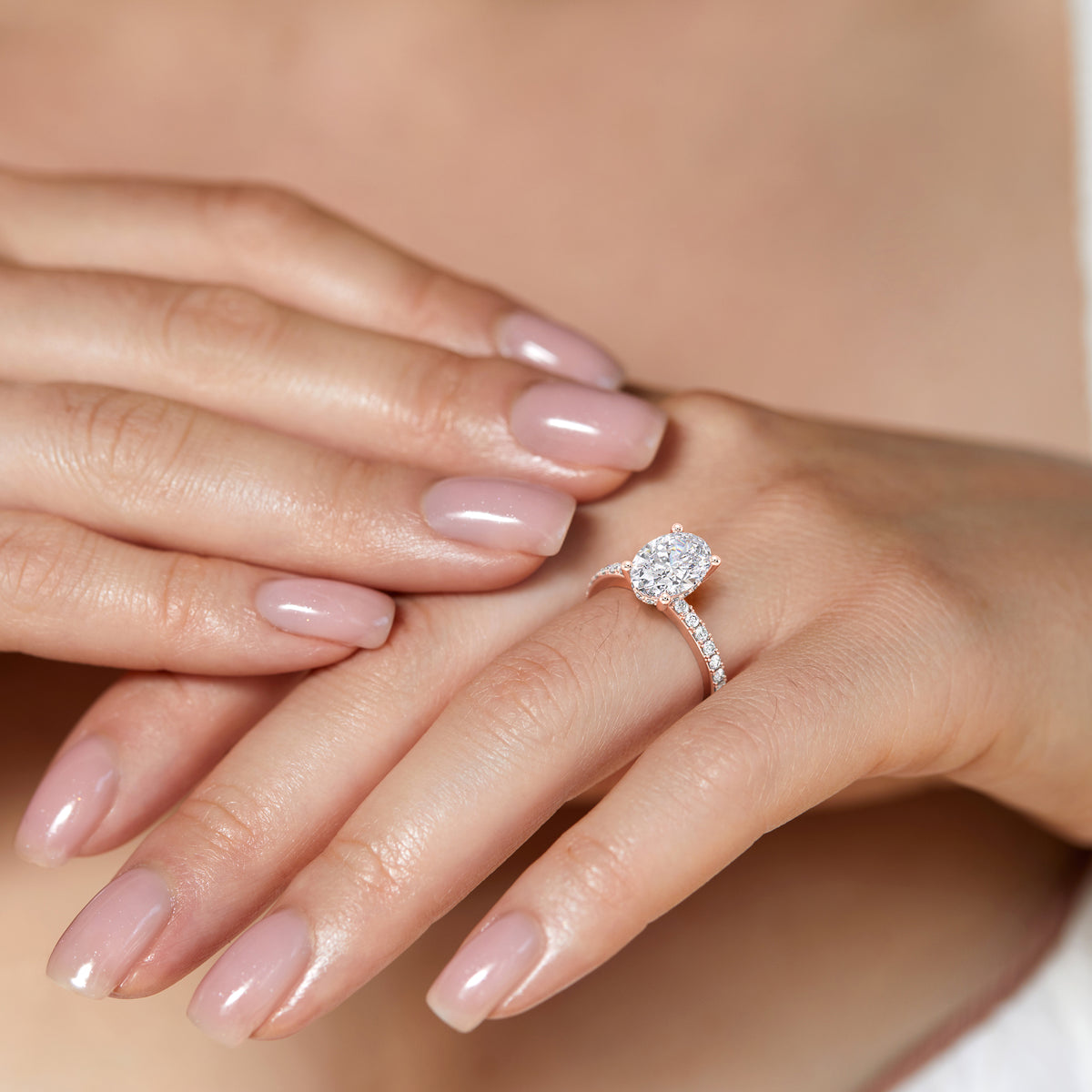 Elegant oval diamond ring in 14K, 18K gold, or platinum worn by a model, showcasing its sparkling allure and refined beauty.