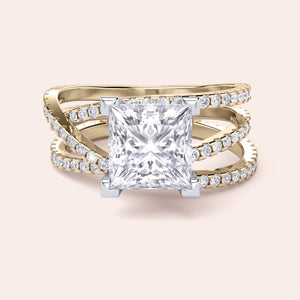 Two-tone 14K gold ring featuring a cushion-cut diamond centerpiece with a swirl pave diamond band in white and yellow gold. 