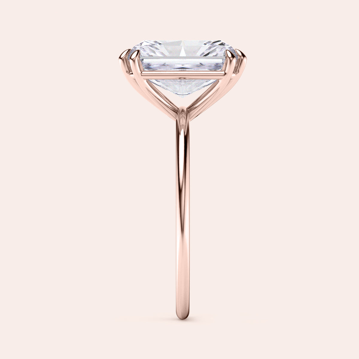 Baguette-cut diamond solitaire ring in rose gold, available in 14K, 18K, or platinum, highlighted in a side profile view.