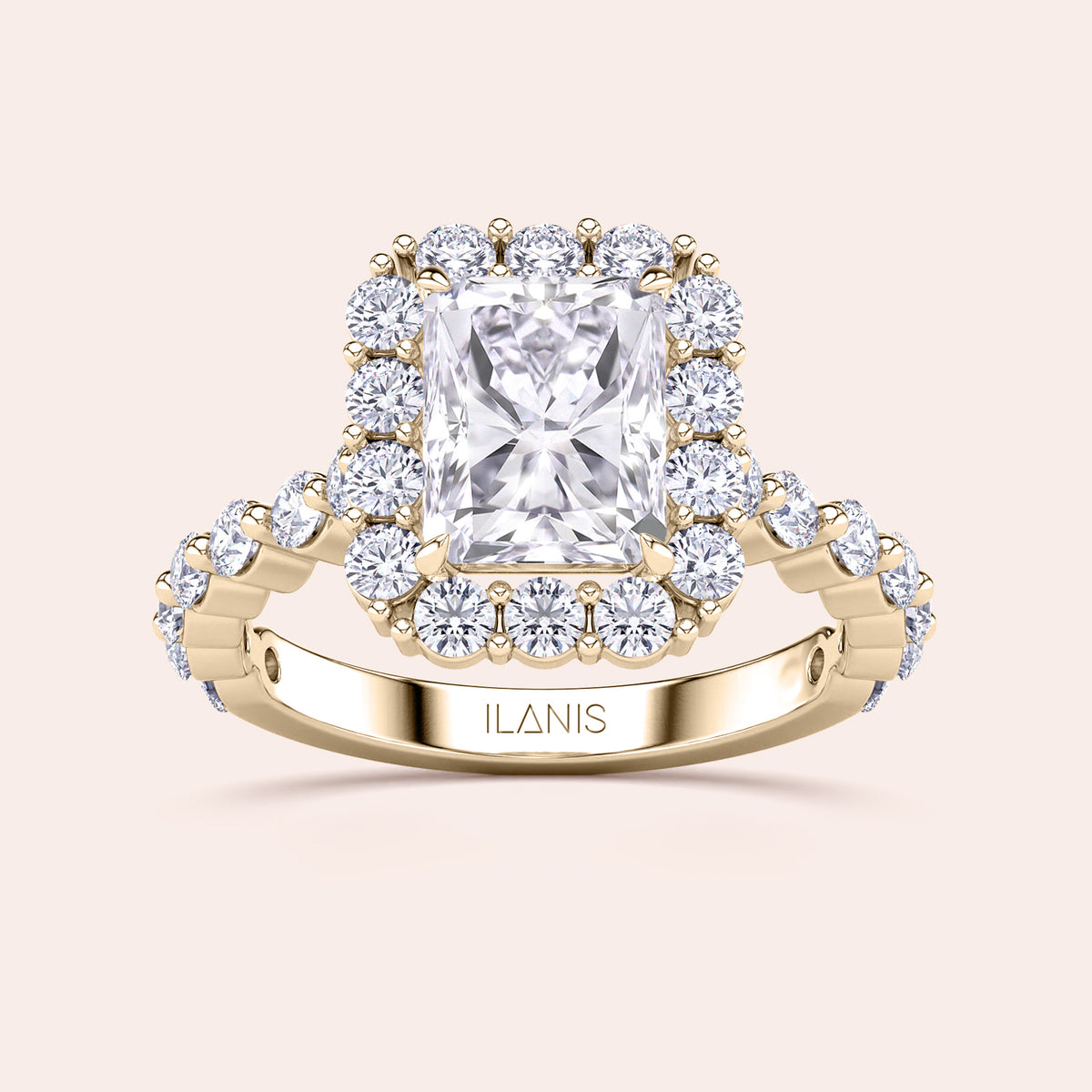 Detailed frontal close-up of radiant-cut halo diamond ring featuring a delicate diamond-accented band in yellow gold 