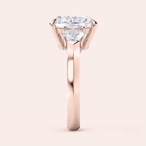 Side view of cushion-cut diamond three stone engagement ring with dazzling shield side stones in rose gold 