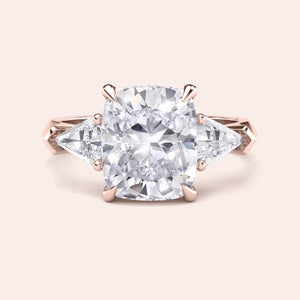 Elegant 14K and 18K rose gold three stone engagement ring featuring a cushion-cut diamond and shield side stones accents.