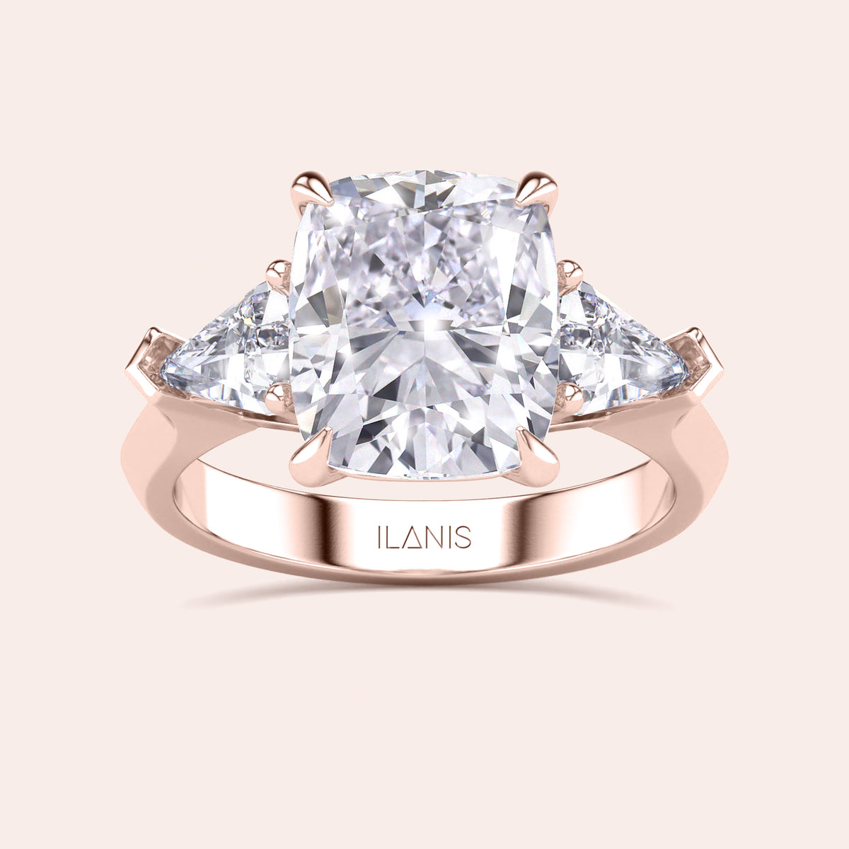 Detailed frontal close-up of elegant cushion-cut diamond ring set in a in a three stone setting with shield side stones rose gold band 