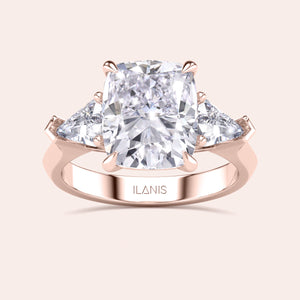 Detailed frontal close-up of elegant cushion-cut diamond ring set in a in a three stone setting with shield side stones rose gold band 