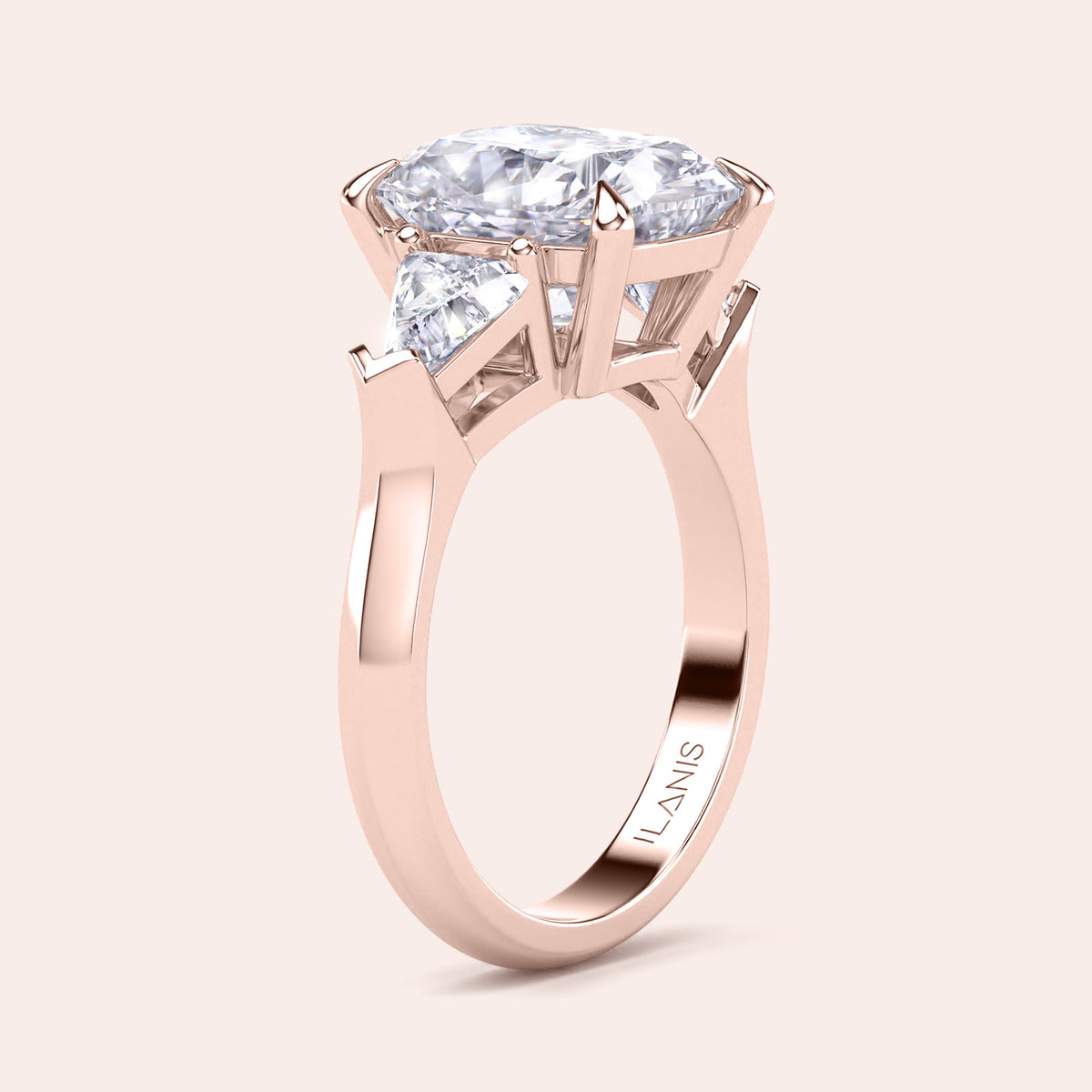 Angled view of cushion-cut diamond three stone engagement ring with dazzling shield side stones in rose gold 