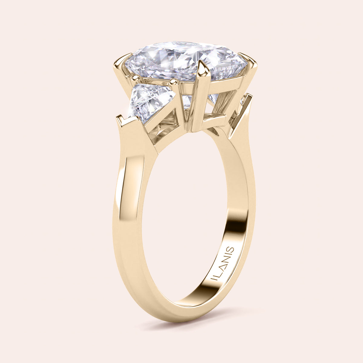 Elegant yellow gold 14K three stone engagement ring featuring a cushion diamond and shield side stones. 