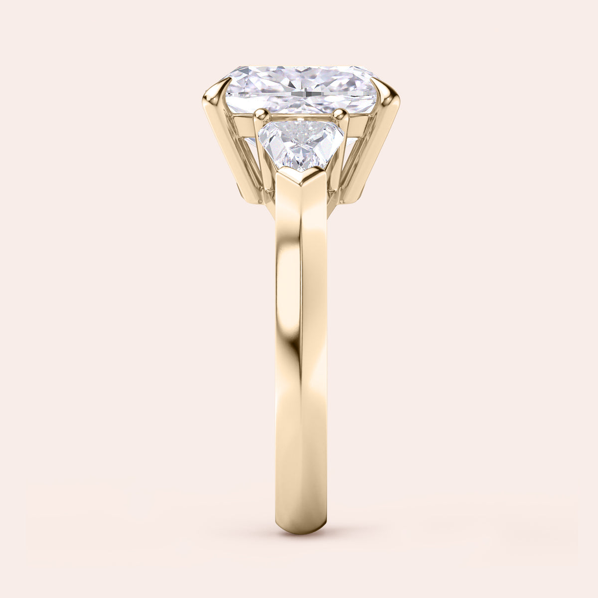 Elegant yellow gold 14K three stone engagement ring featuring a cushion diamond and shield side stones. 