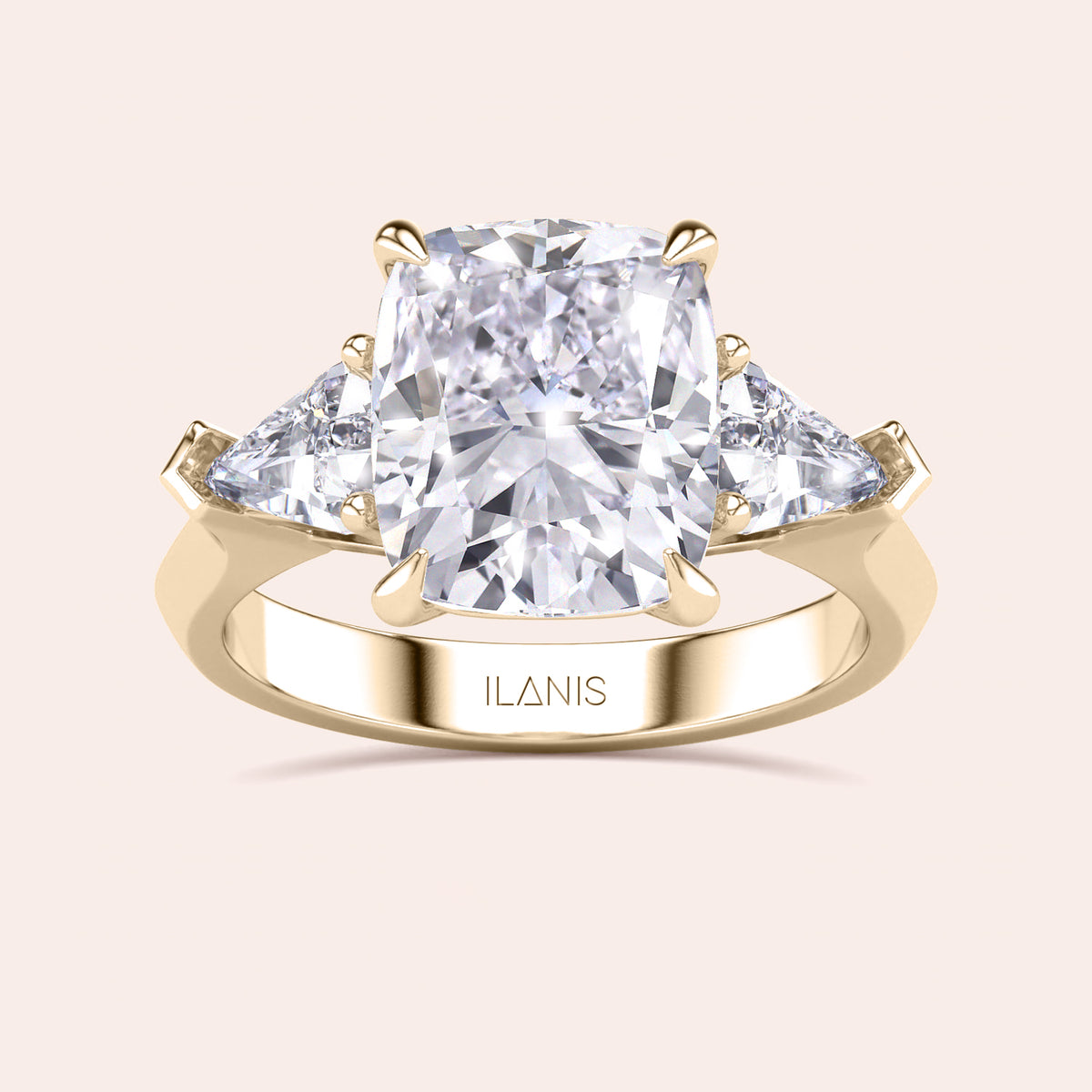 Elegant yellow gold 14K three stone engagement ring featuring a cushion diamond and shield side stones. 