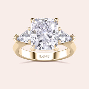 Elegant yellow gold 14K three stone engagement ring featuring a cushion diamond and shield side stones. 