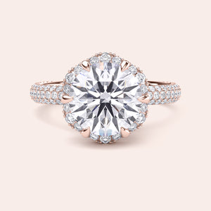 Front view of a luxurious cushion-cut diamond engagement ring in rose gold, adorned with a double halo of diamonds and a sparkling pavé band. 