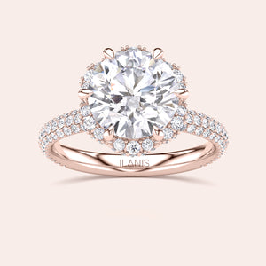 Front view of a luxurious cushion-cut diamond engagement ring in rose gold, adorned with a double halo of diamonds and a sparkling pavé band. 