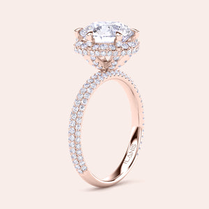 Exquisite rose gold engagement ring featuring a halo of pavé-set diamonds around a radiant cushion-cut center stone, mounted on a fully diamond-encrusted band. 