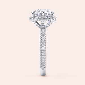 : "Side profile of a white gold cushion-cut diamond engagement ring, highlighting intricate design elements and a diamond-studded band that exudes sophistication. 