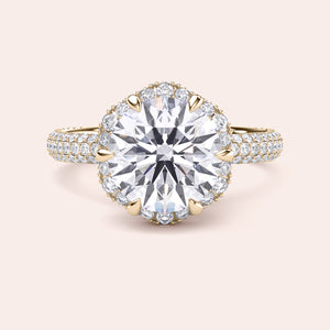 Front view of a luxurious cushion-cut diamond engagement ring in yellow gold, adorned with a double halo of diamonds and a sparkling pavé band. 