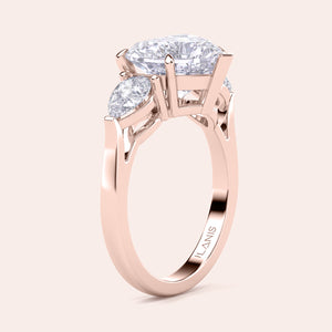 Unique rose gold engagement ring featuring a heart-shaped central diamond flanked by teardrop side diamonds, exemplifying romantic elegance. 