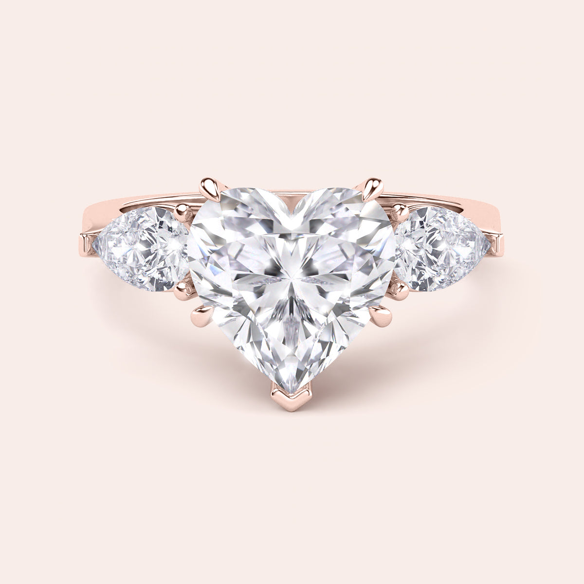 Rose gold engagement ring with a heart-shaped main diamond and elegant teardrop diamonds, designed for a luxurious and timeless proposal. 