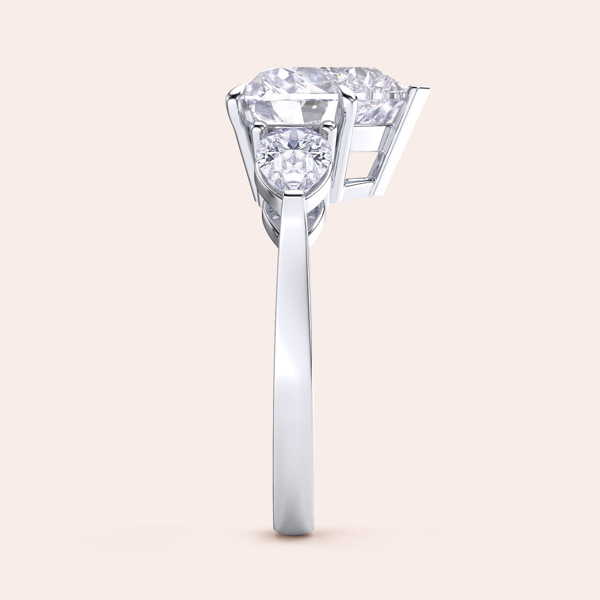 Side view of a white gold heart-shaped diamond engagement ring, showcasing its prong settings and shimmering teardrop side stones. 