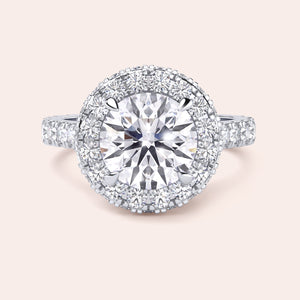 Close-up of a white gold halo engagement ring, emphasizing the intricate detailing and brilliance of its round-cut diamond centerpiece. 