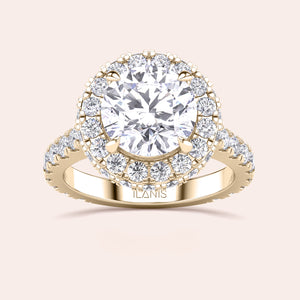 Top view of a yellow gold engagement ring featuring a round-cut diamond with a halo, elegantly designed to catch the light and mesmerize. 