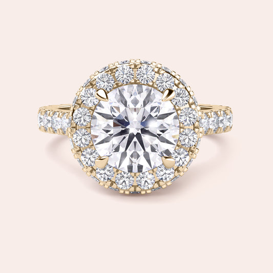 Close-up of a yellow gold halo engagement ring, emphasizing the intricate detailing and brilliance of its round-cut diamond centerpiece. 